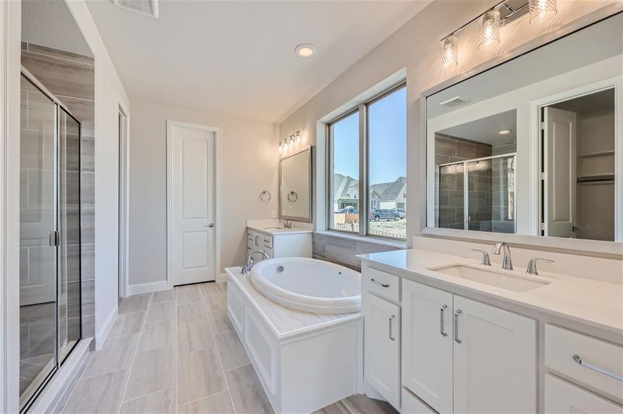 Bathroom featuring tile patterned flooring, separate shower and tub, and dual bowl vanity