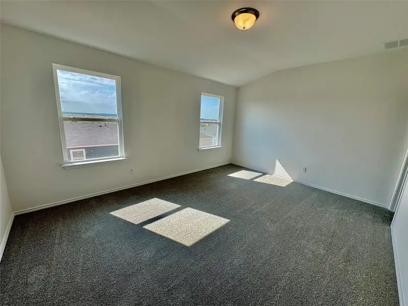 Unfurnished room featuring vaulted ceiling and carpet Unfurnished room featuring vaulted ceiling and carpet