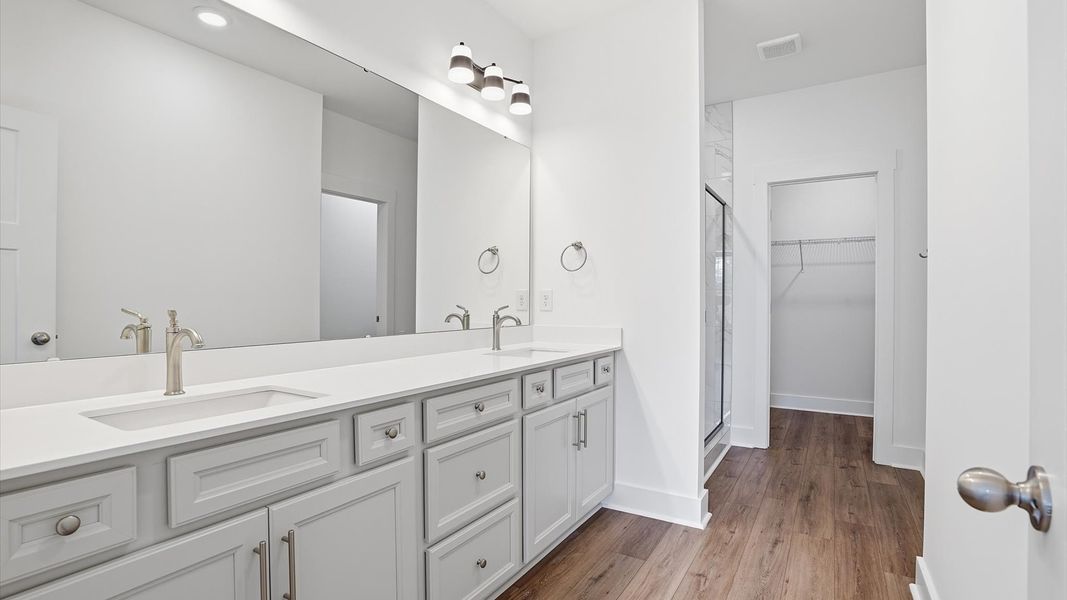 Exceptional en-suite with dual vanity and glass-enclosed walk-in shower for superior everyday comfort at Village at Midway Exceptional en-suite with dual vanity and glass-enclosed walk-in shower for superior everyday comfort at Village at Midway