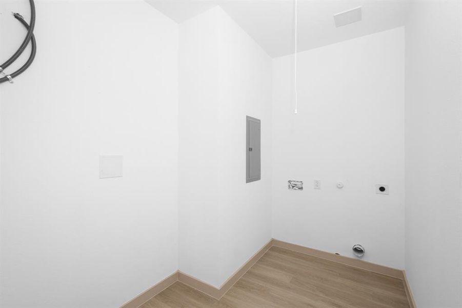 Laundry room featuring light wood finished floors, electric panel, hookup for an electric dryer, baseboards, and laundry area Laundry room featuring light wood finished floors, electric panel, hookup for an electric dryer, baseboards, and laundry area