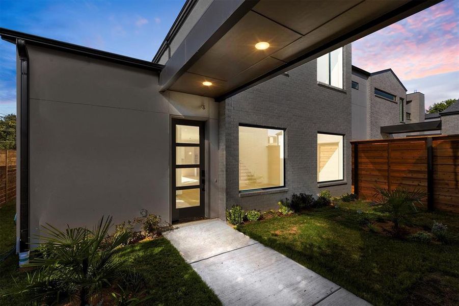 Exterior entry at dusk with a yard