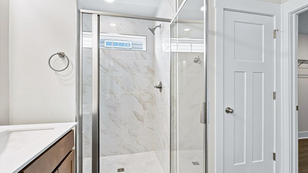 Exceptional en-suite with dual vanity and glass-enclosed tiled walk-in shower for superior everyday comfort