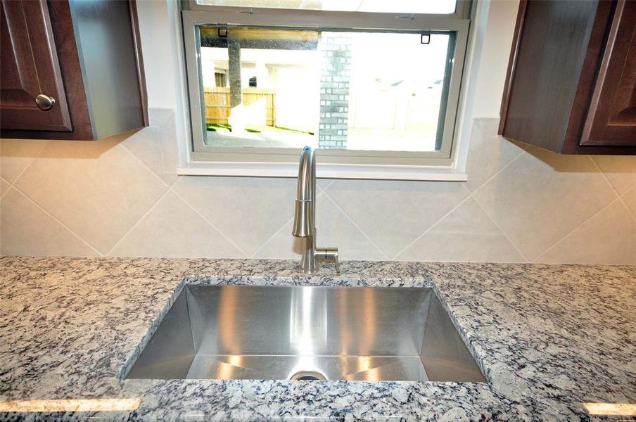 Large single bowl sink with natural lighting above.