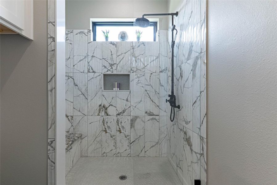 Oversized walk-in shower with sleek tile surround.