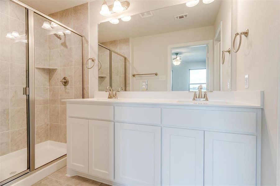 Bathroom with ceiling fan, vanity, and a shower with door