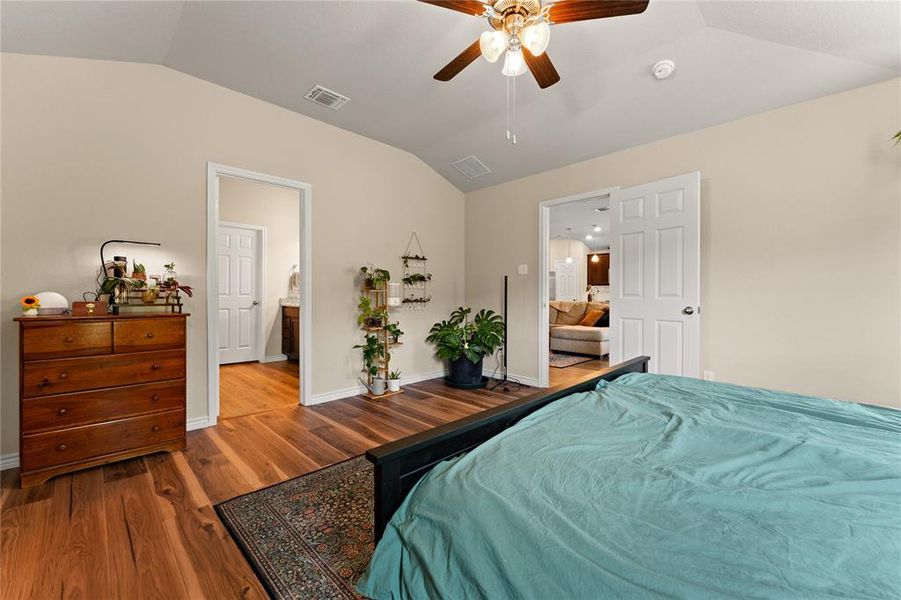 Bedroom with lofted ceiling, wood finished floors, and a ceiling fan