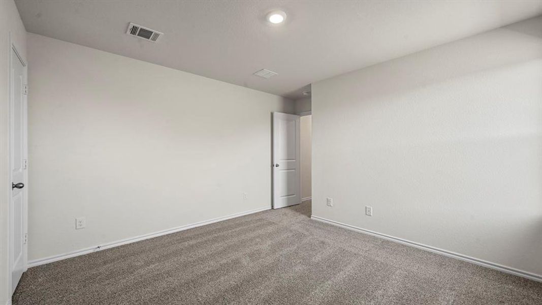Spacious room featuring neutral carpeting and light-toned walls