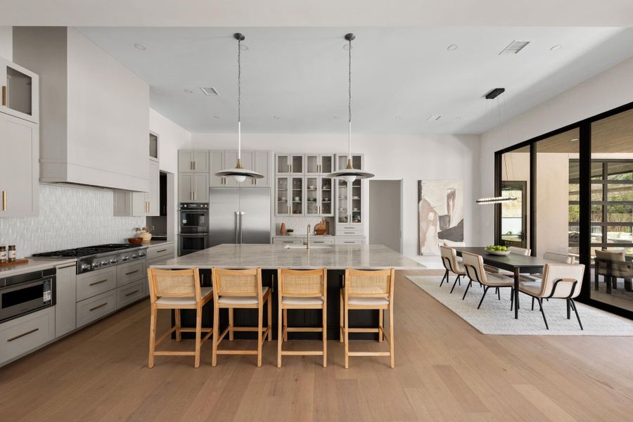 The culinary heart of the home features a massive center island with a breakfast bar, finished in pristine, high-end quartz