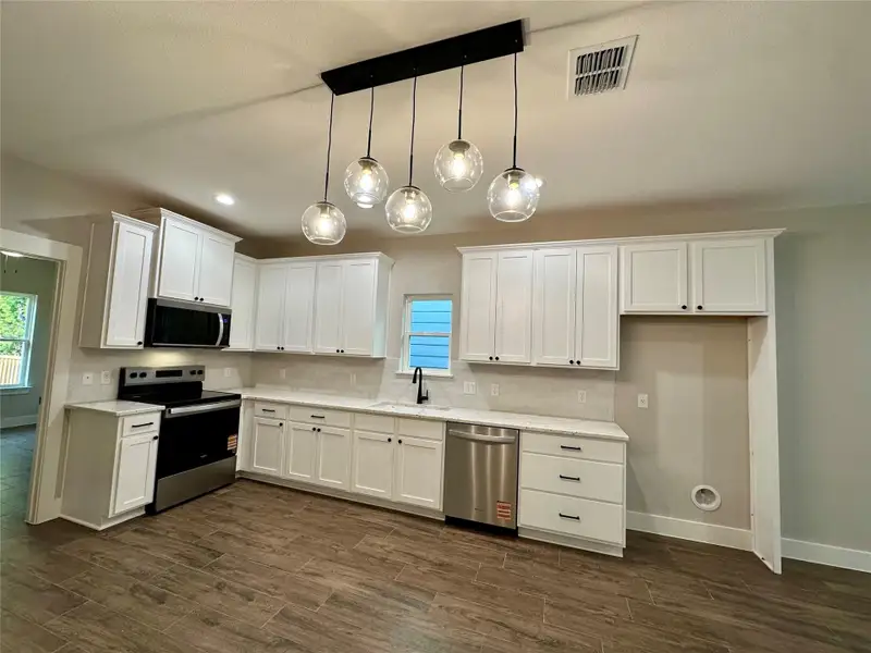 Kitchen featuring stainless steel appliances, white cabinetry, healthy amount of natural light, and recessed lighting