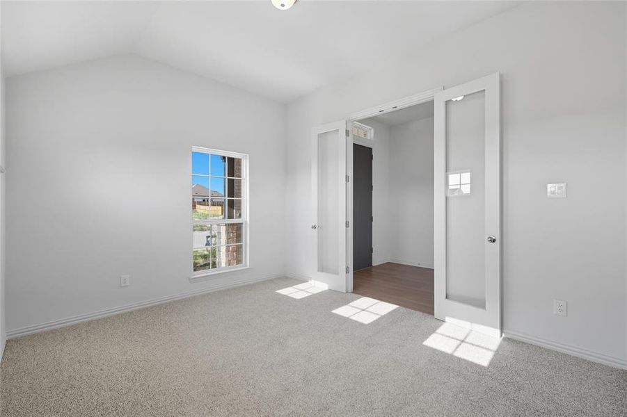 Unfurnished bedroom featuring carpet flooring and lofted ceiling Unfurnished bedroom featuring carpet flooring and lofted ceiling