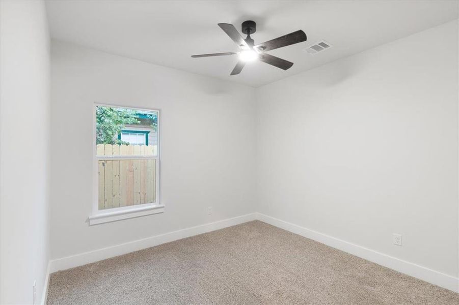 Carpeted empty room featuring ceiling fan