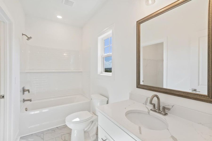 Clean lines and a quartz vanity counter define thi