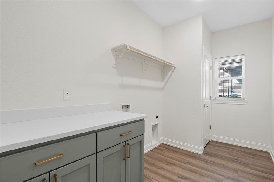 Laundry room with dark wood-style flooring, cabinet space, hookup for an electric dryer, and washer hookup Laundry room with dark wood-style flooring, cabinet space, hookup for an electric dryer, and washer hookup