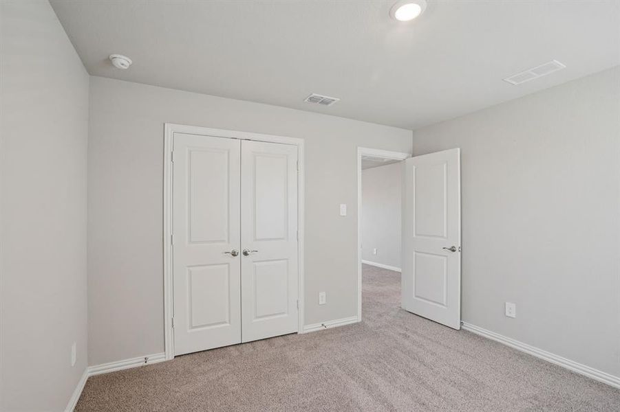 Unfurnished bedroom featuring light colored carpet and a closet