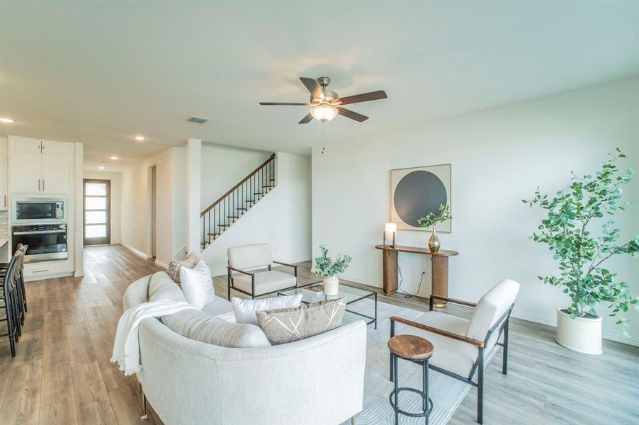 Living room with stairway, recessed lighting, light wood-style floors, and ceiling fan Living room with stairway, recessed lighting, light wood-style floors, and ceiling fan