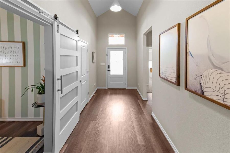 Front door and entryway, featuring lofted ceiling