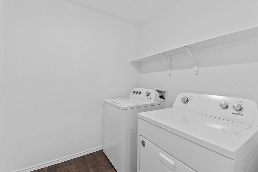 Laundry room featuring laundry area, baseboards, dark wood finished floors, and washer and dryer