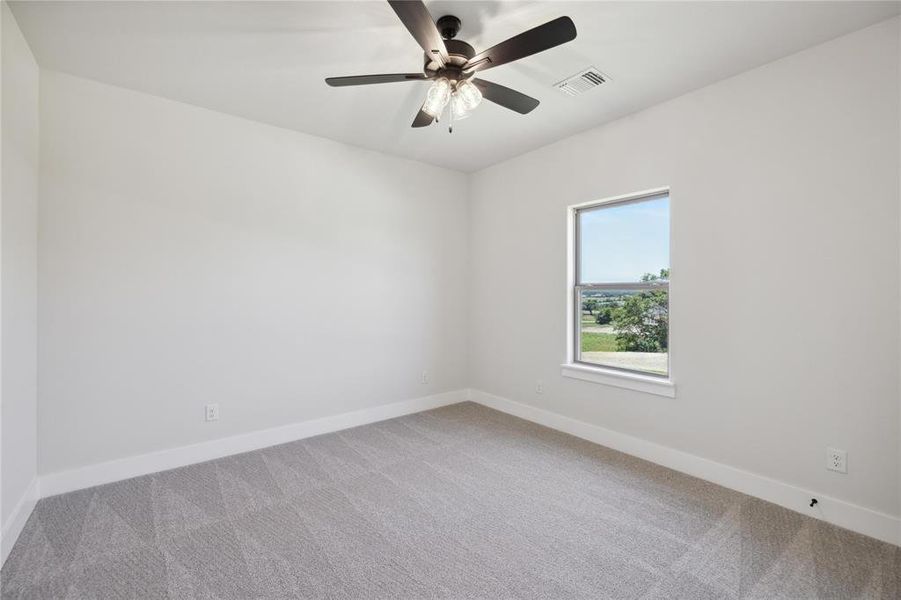 Carpeted spare room with ceiling fan