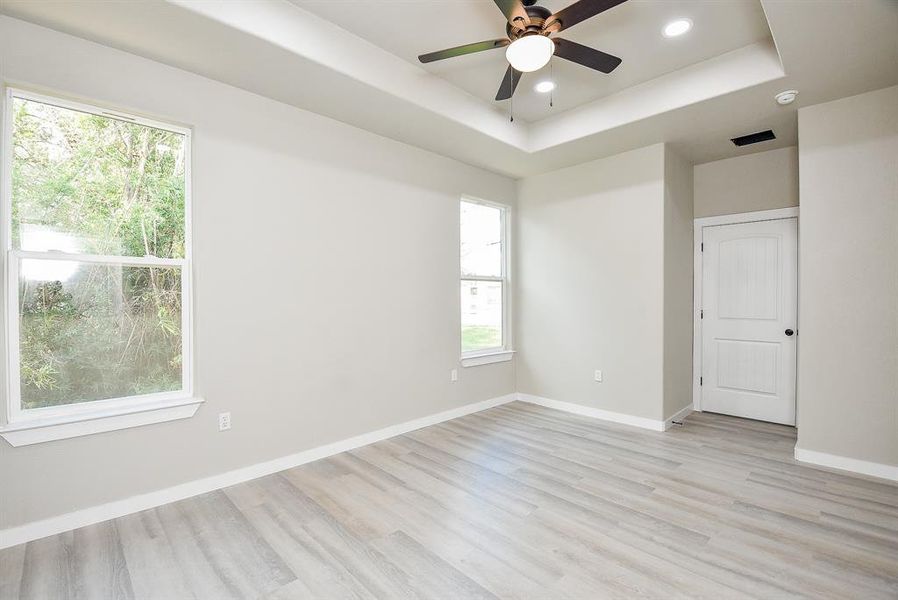 Primary Bedroom with Tray Ceiling, LED lighting, and Ceiling Fan