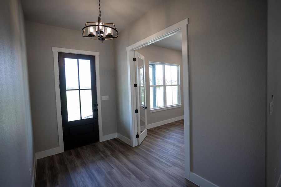 Entryway with dark wood-type flooring and a chandelier Entryway with dark wood-type flooring and a chandelier