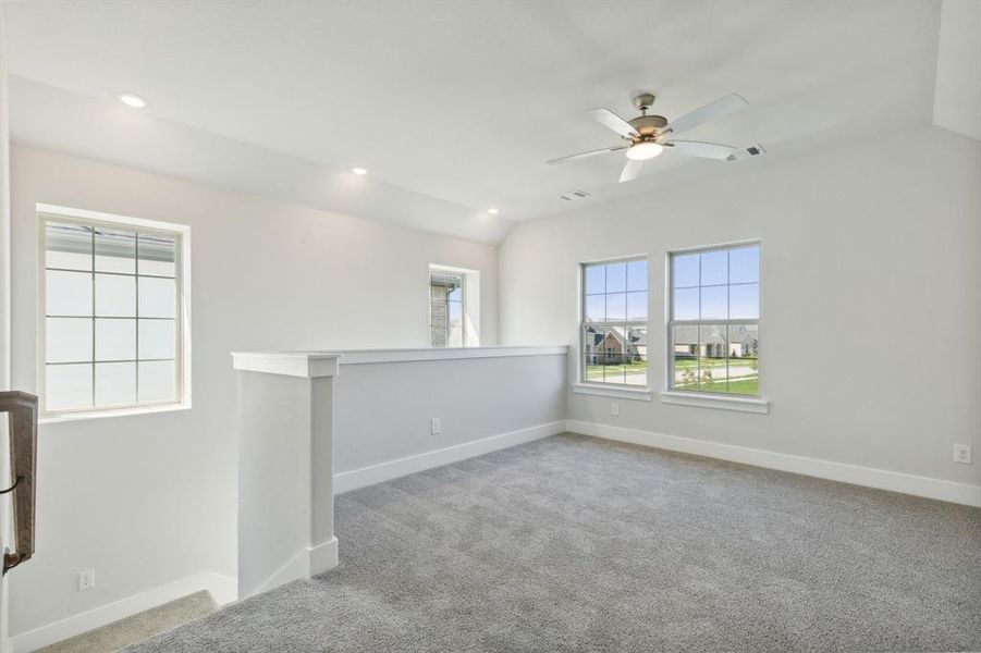 Carpeted empty room featuring lofted ceiling