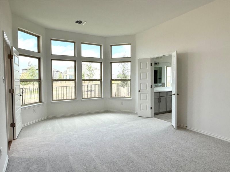 Unfurnished bedroom with light colored carpet and connected bathroom Unfurnished bedroom with light colored carpet and connected bathroom