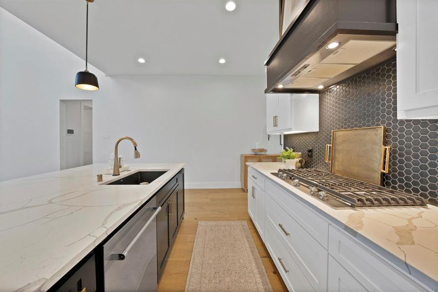 Modern kitchen featuring white cabinetry, a dark hexagonal tile backsplash, light wood-finish flooring, and light countertops Modern kitchen featuring white cabinetry, a dark hexagonal tile backsplash, light wood-finish flooring, and light countertops