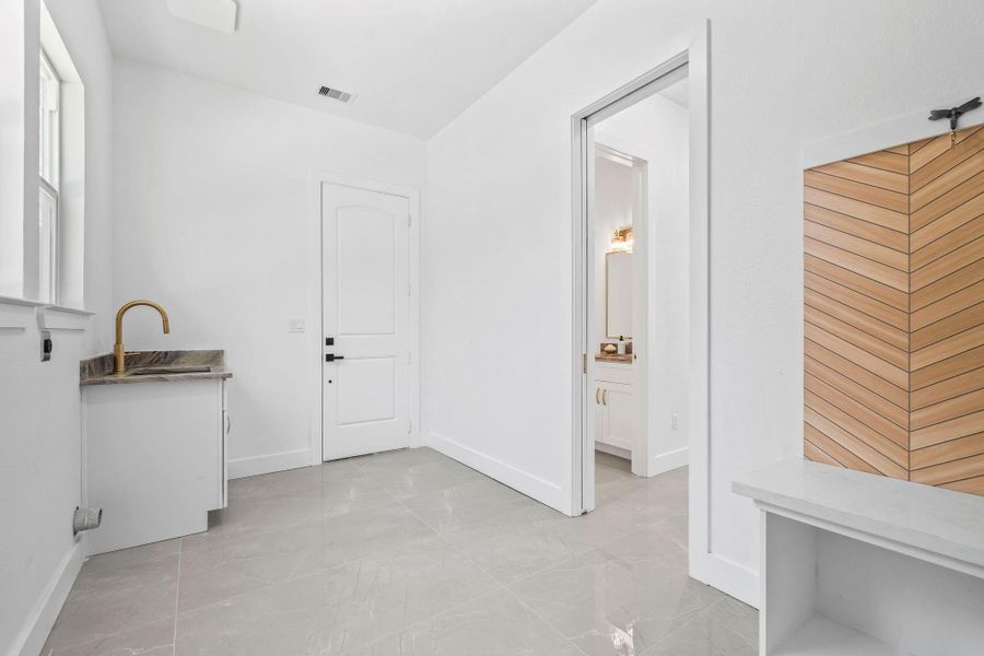 Utility room next to garage area with sink to bathe your pet or wash anything you need
