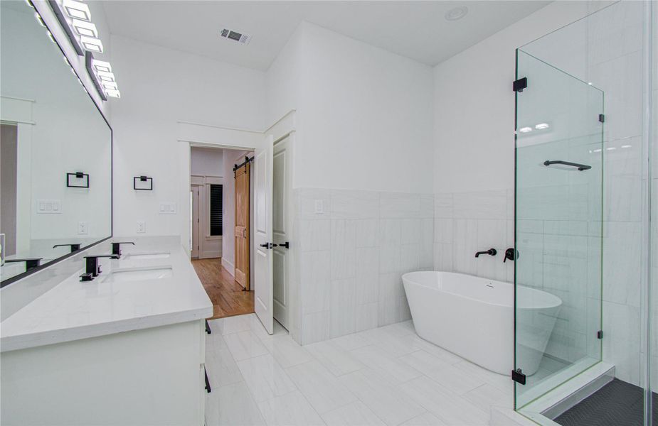The clean white tiles and recessed lighting contribute to a bright and airy atmosphere.