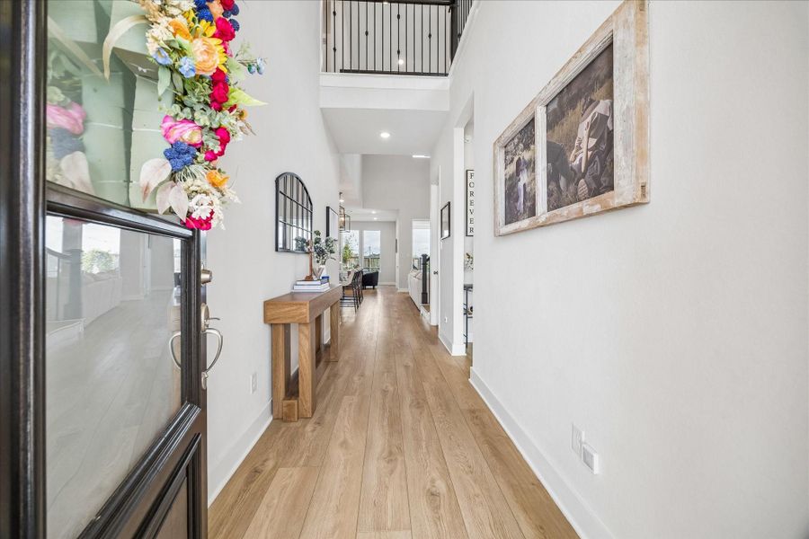 Step inside to a bright and welcoming entry hallway with soaring ceilings and an open view from the second floor above, creating an airy and inviting first impression.