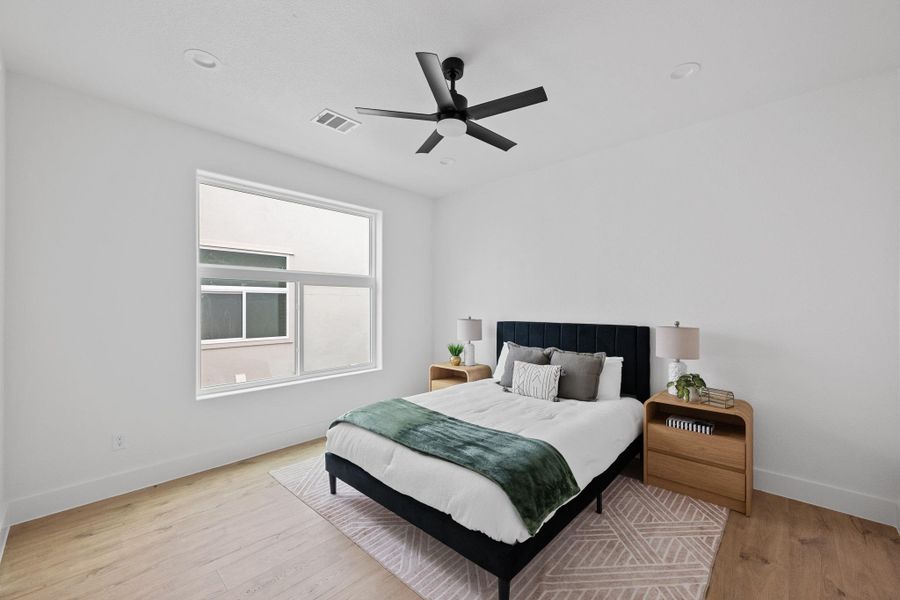 Bright bedroom featuring a large window, recessed lighting, and a contemporary ceiling fan