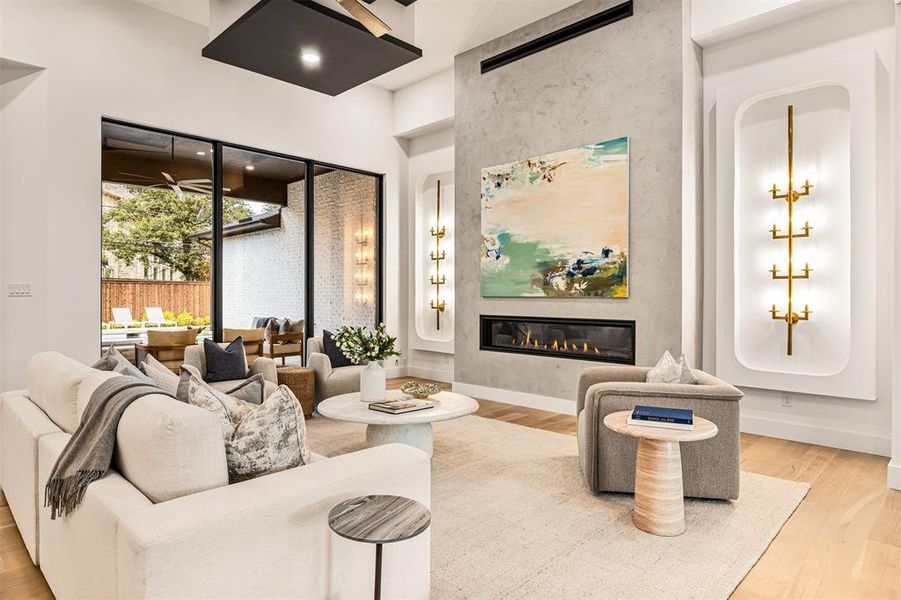 Walls of windows line the living room, bringing in natural light and keeping the space visually connected to the backyard and pool area