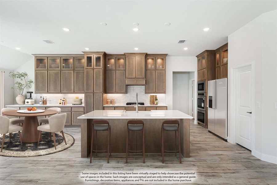 Kitchen with brown wood cabinets, large center island with seating, and stainless steel appliances