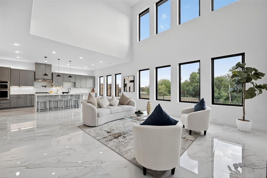 Living room with light marble finish floors, recessed lighting, and a high ceiling
