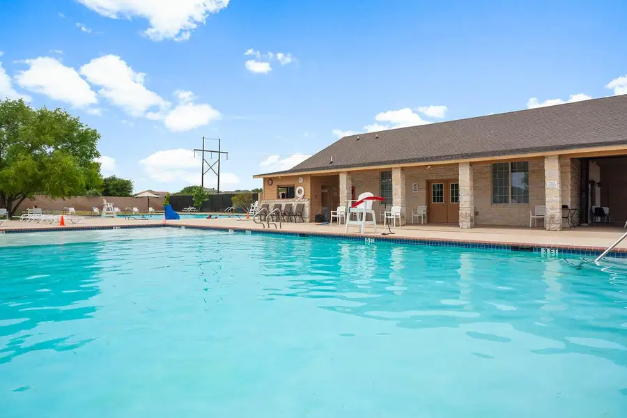 A refreshing outdoor pool with a clubhouse provides an inviting community gathering space.