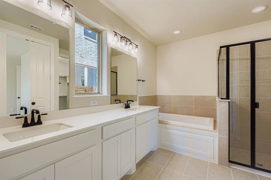 Full bathroom featuring a shower stall, a garden tub, light tile patterned floors, double vanity, and recessed lighting
