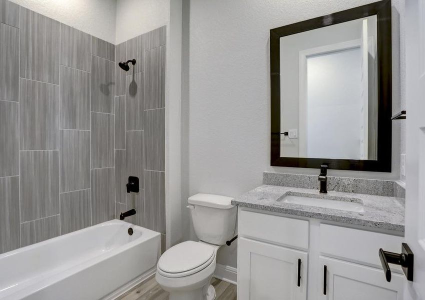 Guest bathroom with a dual shower and tub, lined with tile.