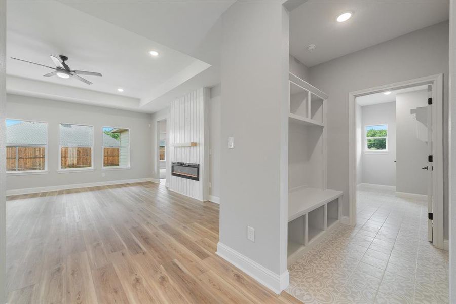 Mudroom featuring ceiling fan, light tile floors, and a raised ceiling