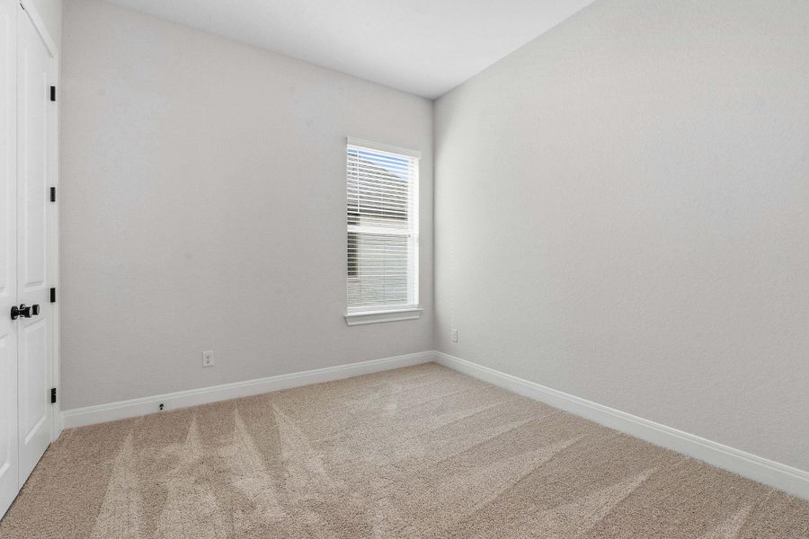 Empty room with baseboards and light colored carpet
