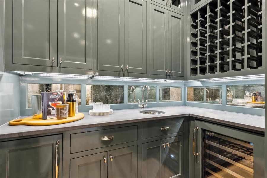 Bar featuring beverage cooler, backsplash, a sink, and wet bar