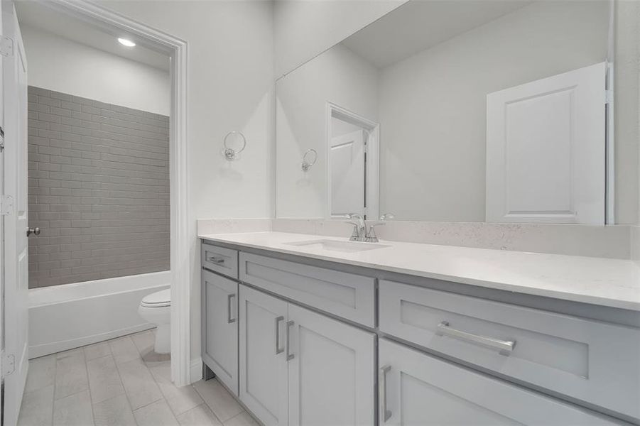 Bathroom featuring shower / tub combination, vanity, and toilet