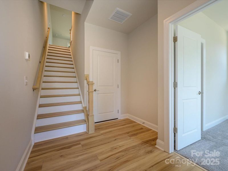 Front Entry With Oak Box Stairs Leading to Guest Bedroom.