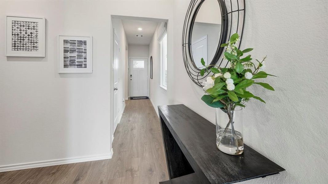 Corridor featuring light wood-style flooring and baseboards Corridor featuring light wood-style flooring and baseboards