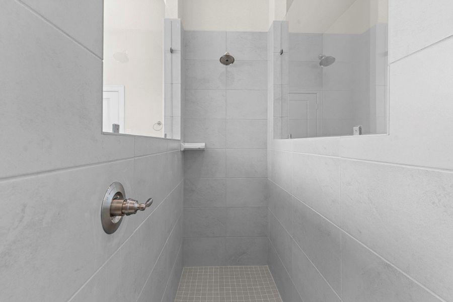 Spacious walk-in shower with sleek tile surround, and premium fixtures, blending modern design with comfort.