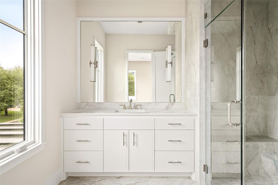 A thoughtfully designed secondary bath where quartzite and fluted textures add depth to the walk-in shower with built-in bench.