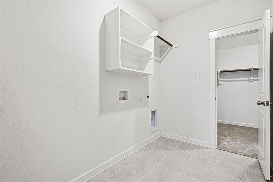 Laundry area featuring light tile patterned floors, electric dryer hookup, washer hookup, and hookup for a gas dryer