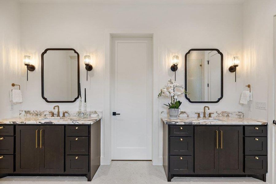 Dual vanities with stone counters and elegant mirrors define this primary bathroom's sophisticated appeal.