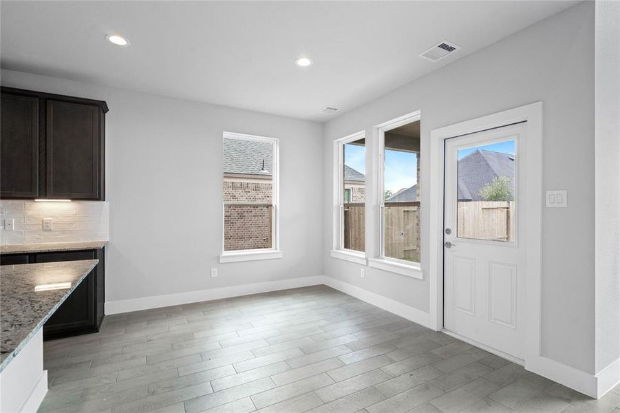 Start your day off right with a cup of coffee sitting with your family in the lovely breakfast nook! Featuring large windows with blinds, custom paint and gorgeous flooring.