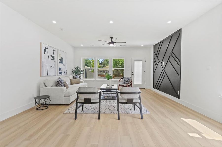 Living area with light wood-style flooring, recessed lighting, and a ceiling fan Living area with light wood-style flooring, recessed lighting, and a ceiling fan