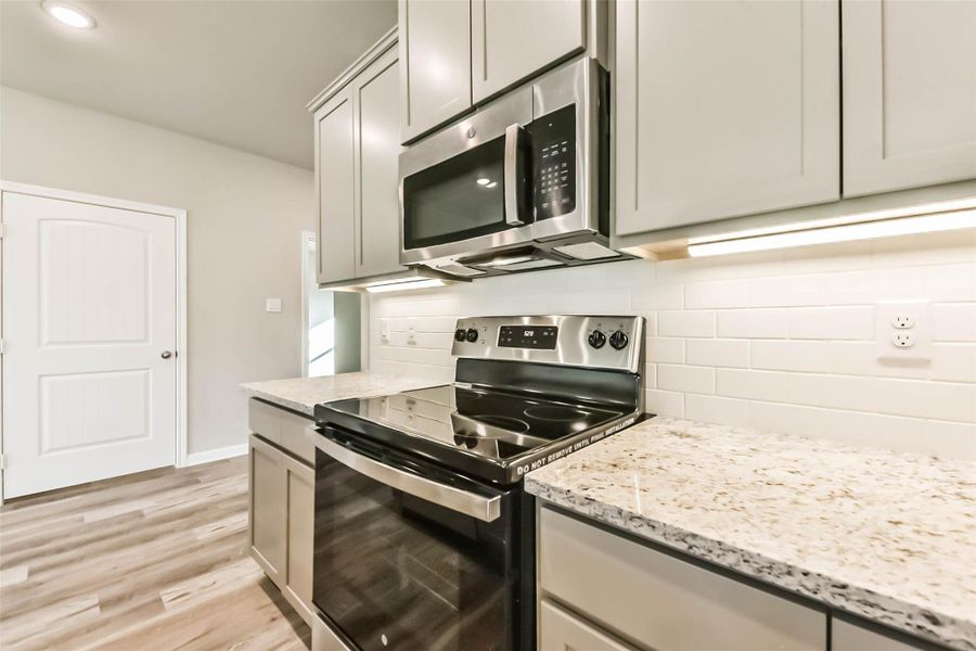 The kitchen features a brand-new microwave, oven, and refrigerator!